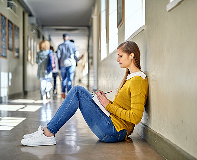 Buy stock photo Full length shot of an attractive young female student studying in the university corridor