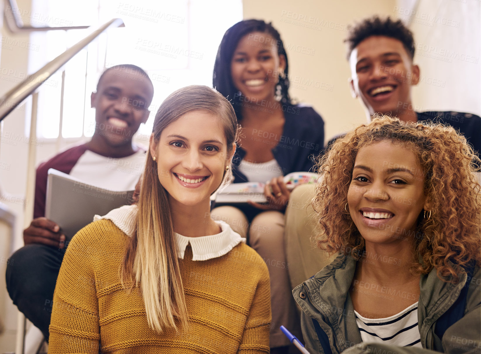 Buy stock photo Cropped portrait of a group of young university students sitting on their campus staircase