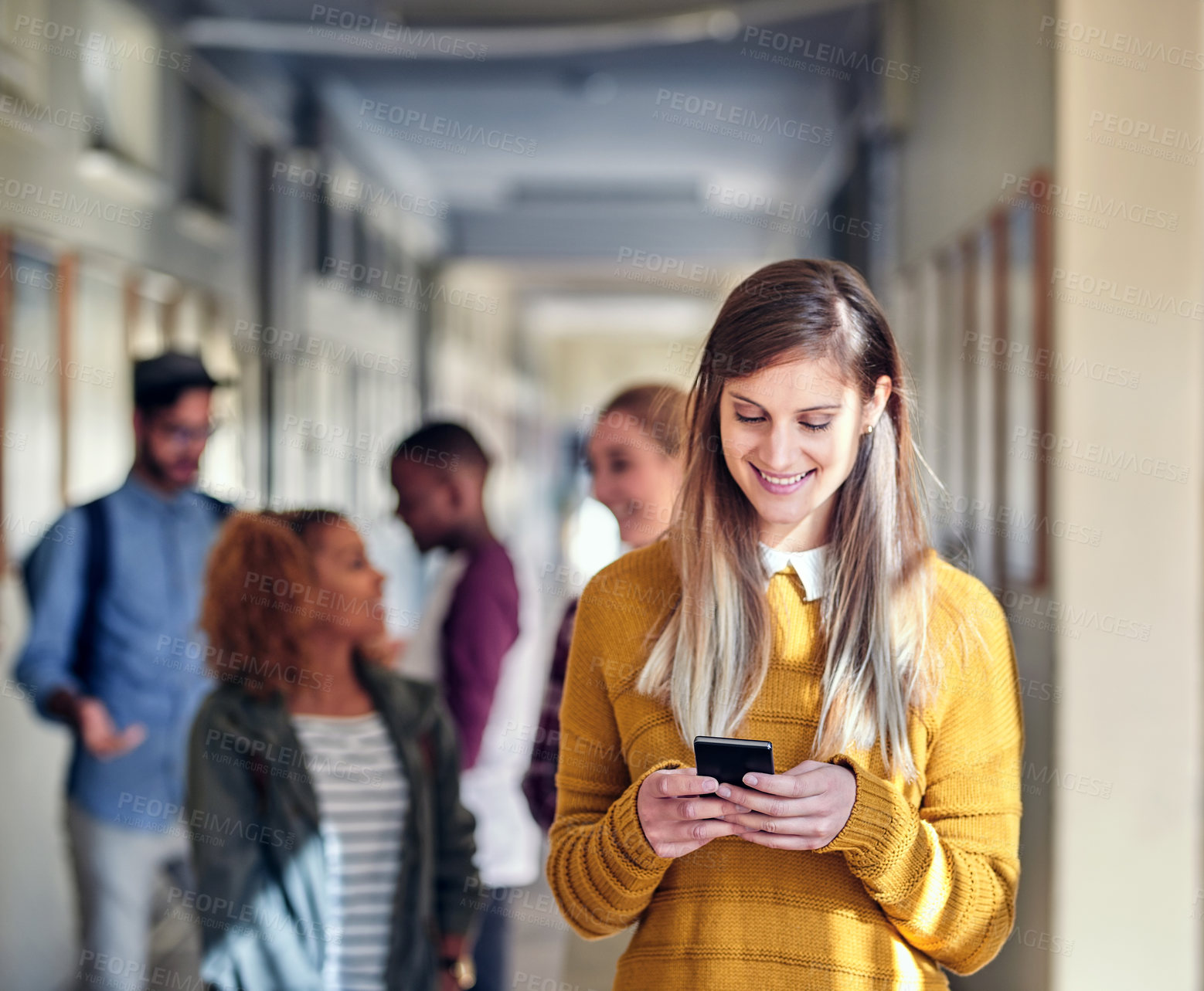 Buy stock photo Education, phone and social media with student woman in hallway of college or university for communication. App, smile and text message with happy learner on school campus for development or learning