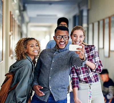 Buy stock photo Cropped shot of a group of young university students taking selfies on campus