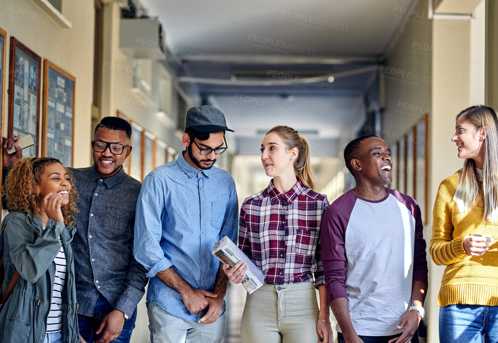 Buy stock photo Cropped shot of a group of young university students walking through the campus halls