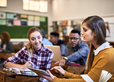 Buy stock photo Cropped shot of university students looking at a tablet in class