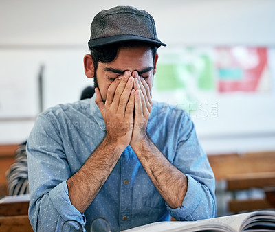 Buy stock photo Cropped shot of an university student covering his face in class