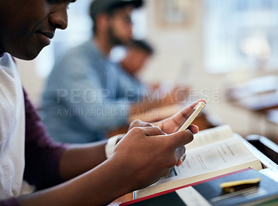 Buy stock photo Cropped shot of university students using their smartphones in class
