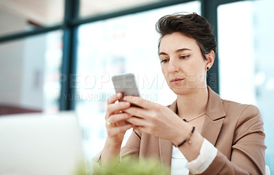 Buy stock photo Cropped shot of a young designer using her phone at her desk