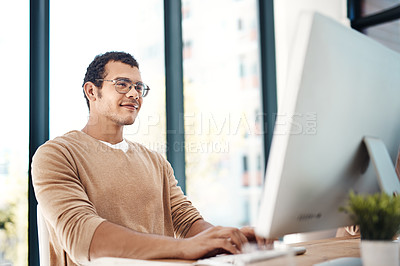 Buy stock photo Shot of a young designer working on a computer in an office