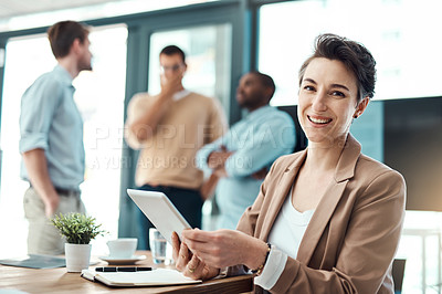 Buy stock photo Portrait of a young businesswoman using a digital tablet with her colleagues in the background