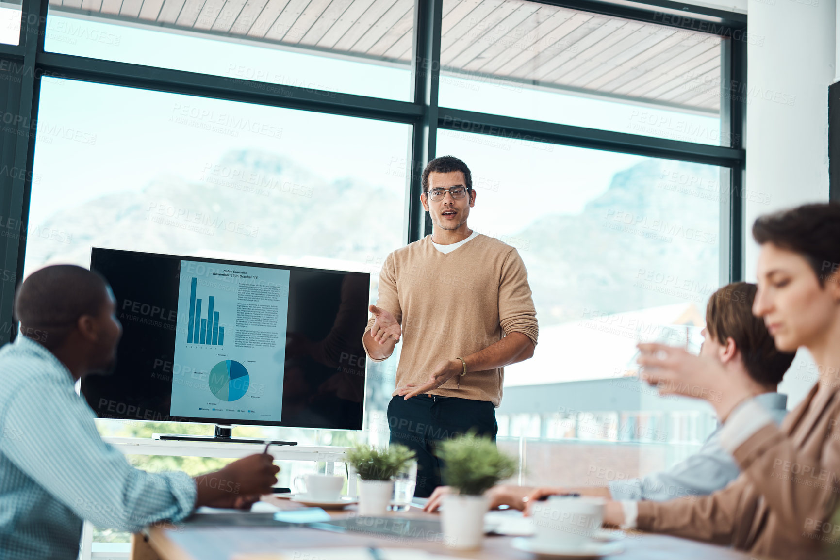 Buy stock photo Shot of a young businessman giving a presentation to his colleagues in an office