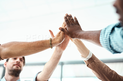 Buy stock photo Shot of a group of businesspeople high fiving each other in an office