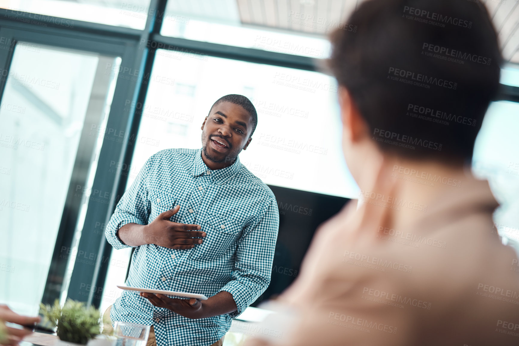 Buy stock photo Shot of a young businessman giving a presentation to his colleagues in an office