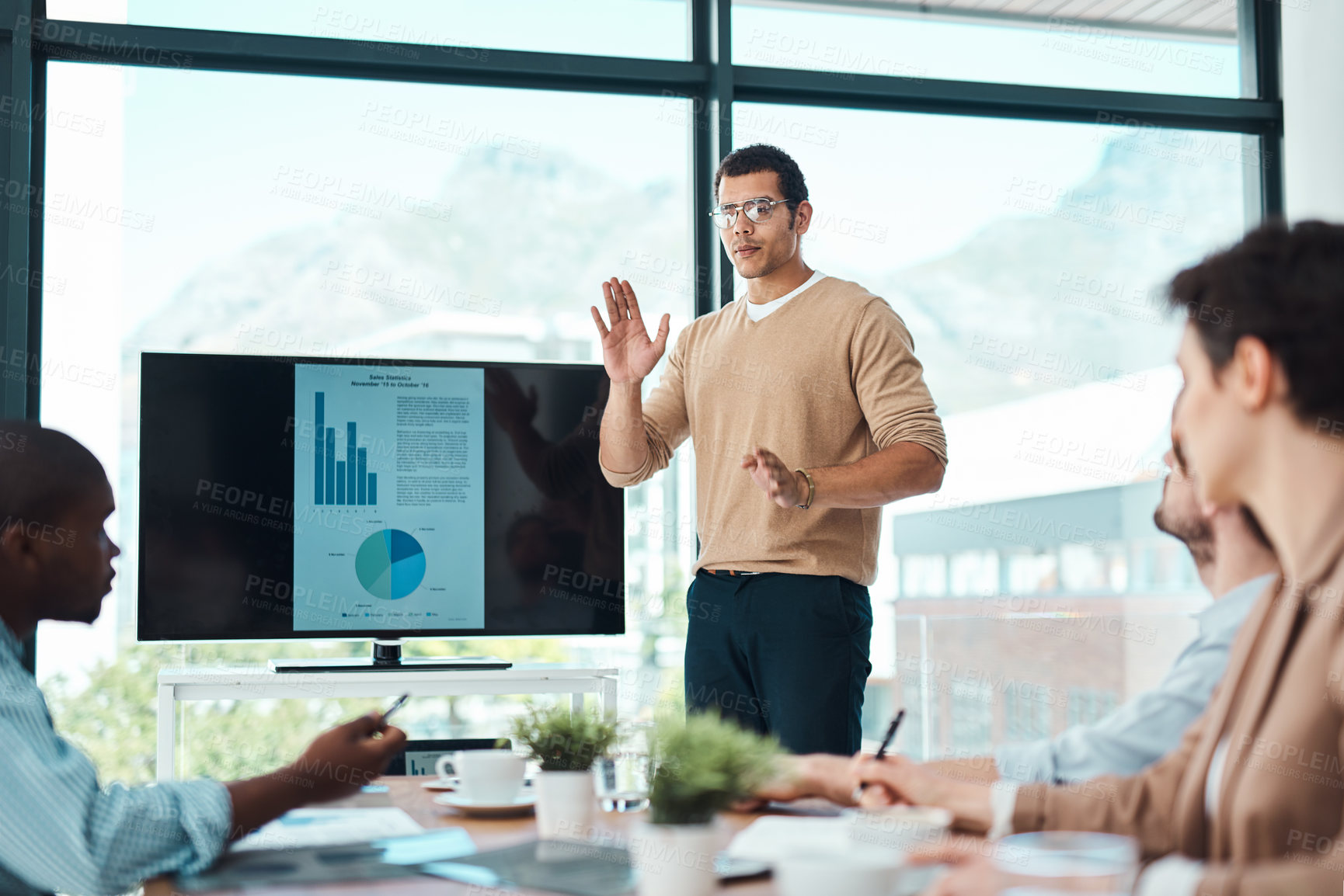 Buy stock photo Shot of a young businessman giving a presentation to his colleagues in an office