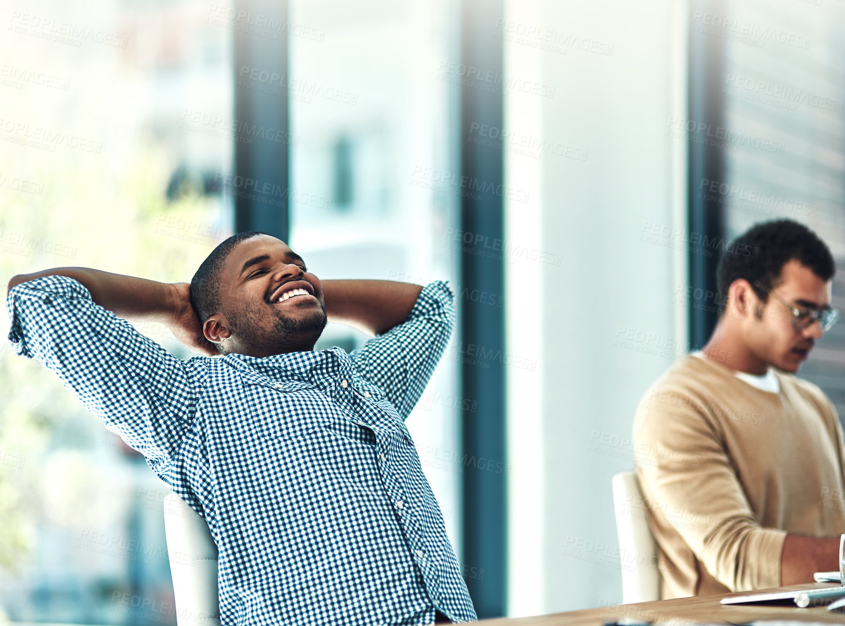 Buy stock photo Shot of a young designer looking relaxed at his desk