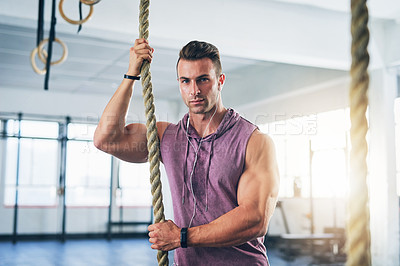 Buy stock photo Portrait of a muscular young man climbing a rope at the gym