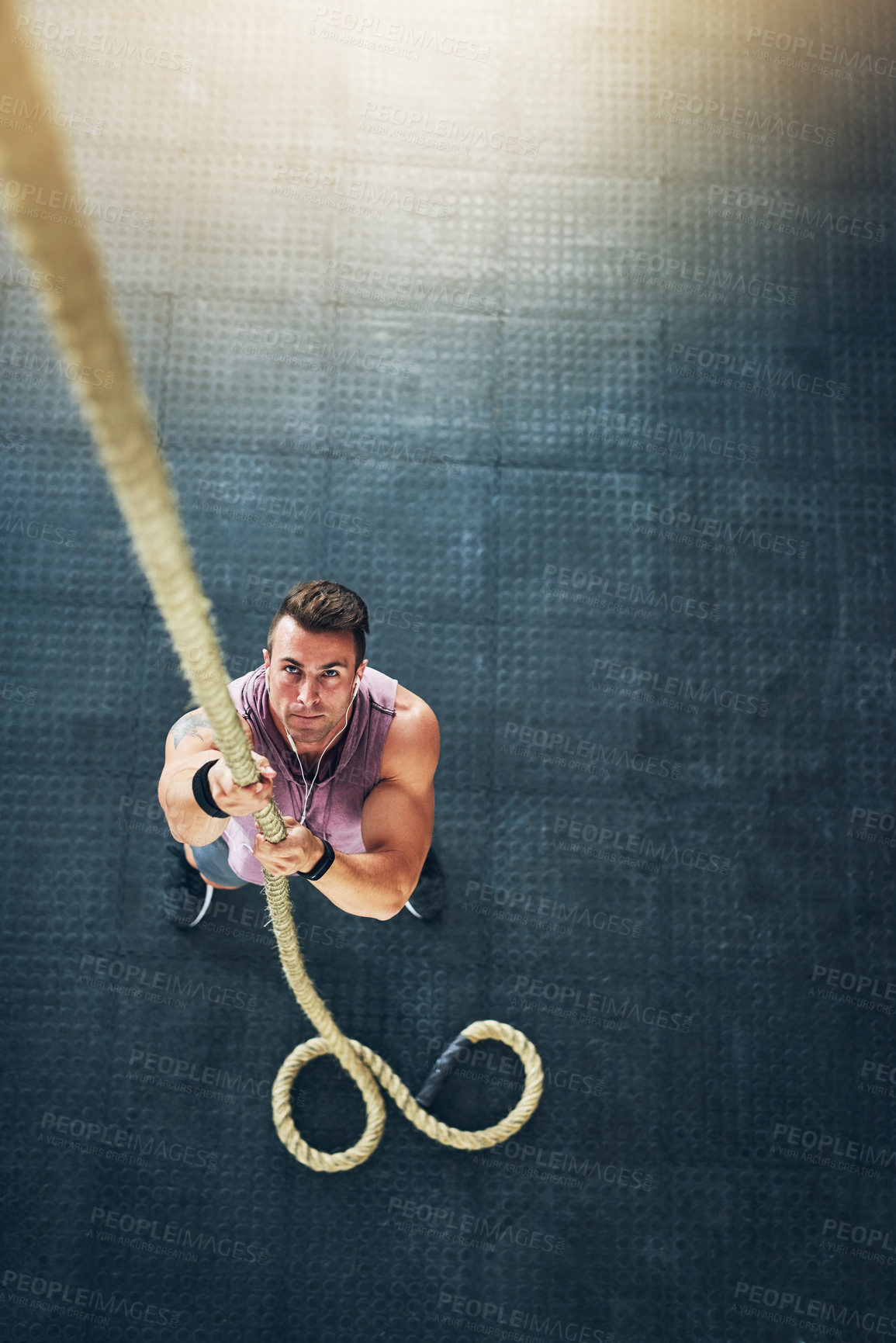 Buy stock photo Above, rope climbing and man in gym, fitness and energy with wellness, exercise and challenge. Person, bodybuilder or guy with endurance, top view and training with full body workout or motivation