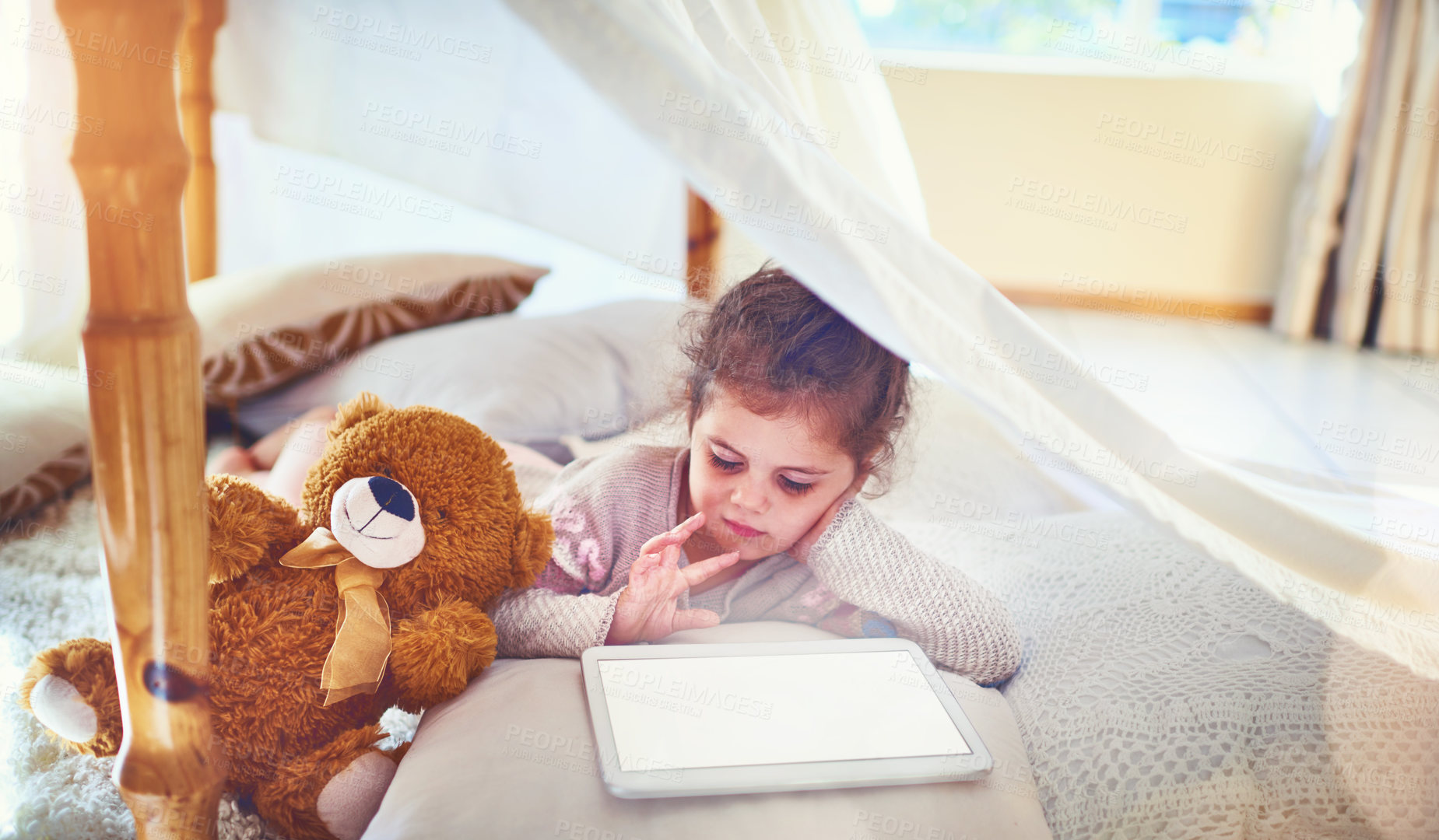 Buy stock photo Shot of an adorable little girl using a digital tablet at home