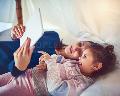 Buy stock photo Shot of a mother and her little daughter using a digital tablet together at home