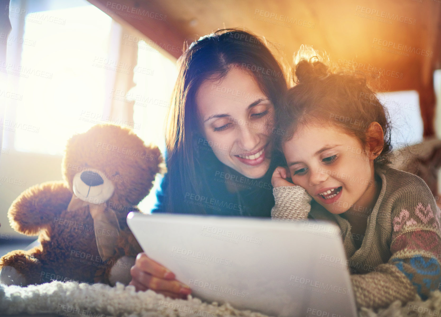 Buy stock photo Home, mother and girl with tablet, kid and reading ebook with happiness, bonding together and relax. Family, single parent or mama with daughter, tech and digital app for cartoon movie or online game