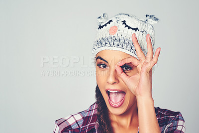 Buy stock photo Cropped shot of a young woman posing with a character beanie