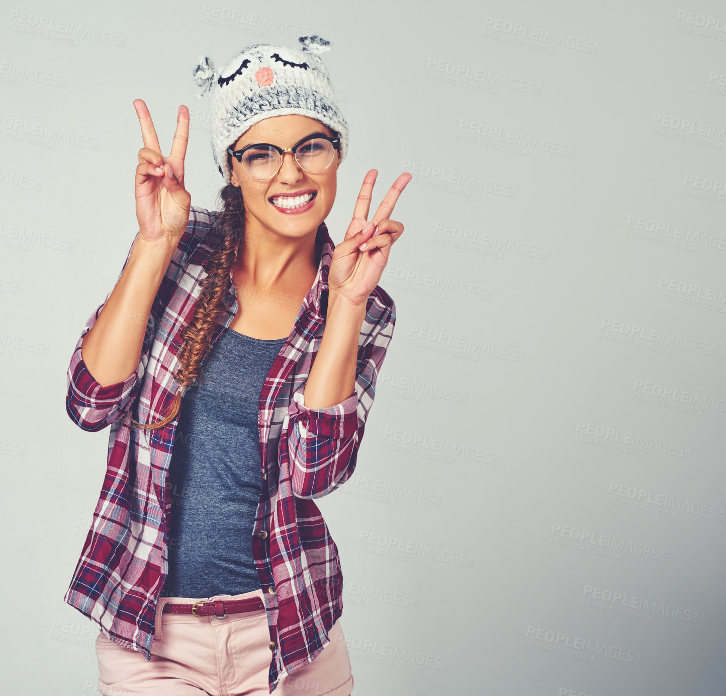 Buy stock photo Woman, portrait and peace sign with fashion in studio for goofy, personality or playful outfit. Female person, happy and emoji gesture with animal beanie for fun, style or clothes by white background