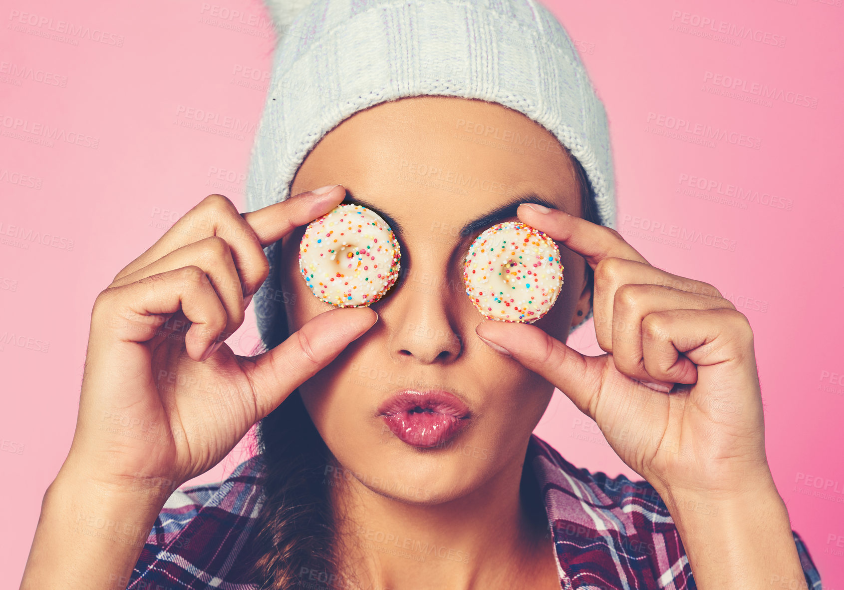 Buy stock photo Cookies, silly and face of woman in studio for pastry chef, sweet and confectionery bakery. Recipe, sugar and diet with person and biscuit snack on eyes on pink background for dessert, food and candy