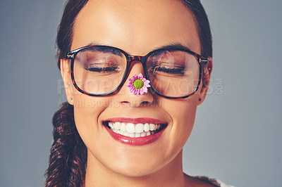 Buy stock photo Woman, glasses and flower for eye care in studio, lens and sustainable frames for optometry. Female person, optical insurance and proud for eco friendly healthcare, spectacles and gray background