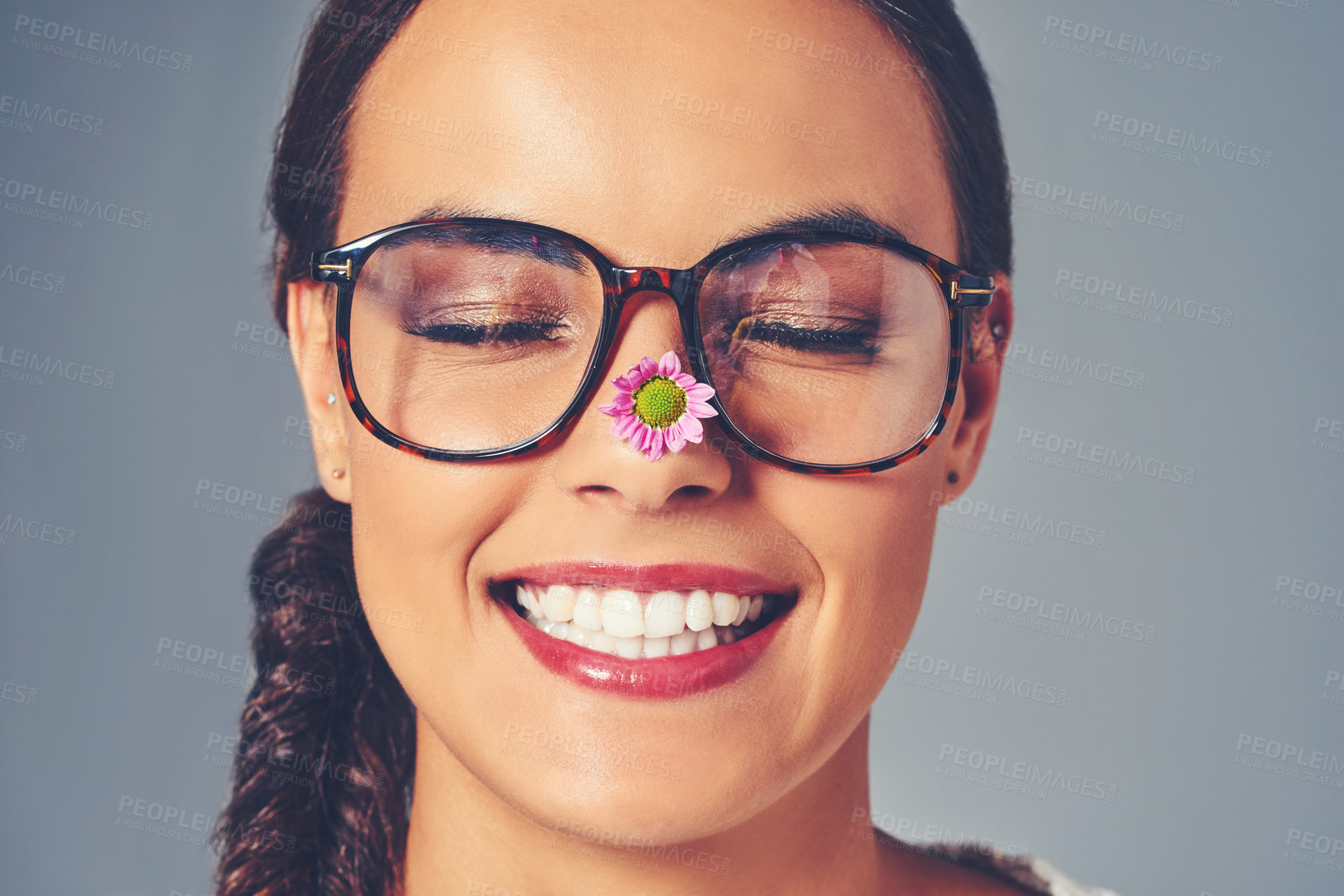 Buy stock photo Woman, glasses and flower for eye care in studio, lens and sustainable frames for optometry. Female person, optical insurance and proud for eco friendly healthcare, spectacles and gray background