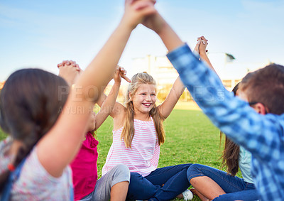 Buy stock photo School kids, group and circle with holding hands on grass for games, care and bonding in summer. Girl, boy and children with diversity, excited and solidarity on lawn for play at education academy