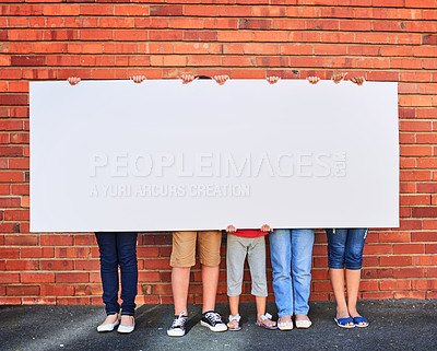 Buy stock photo Shot of a group of young children holding a blank sign against a brick wall