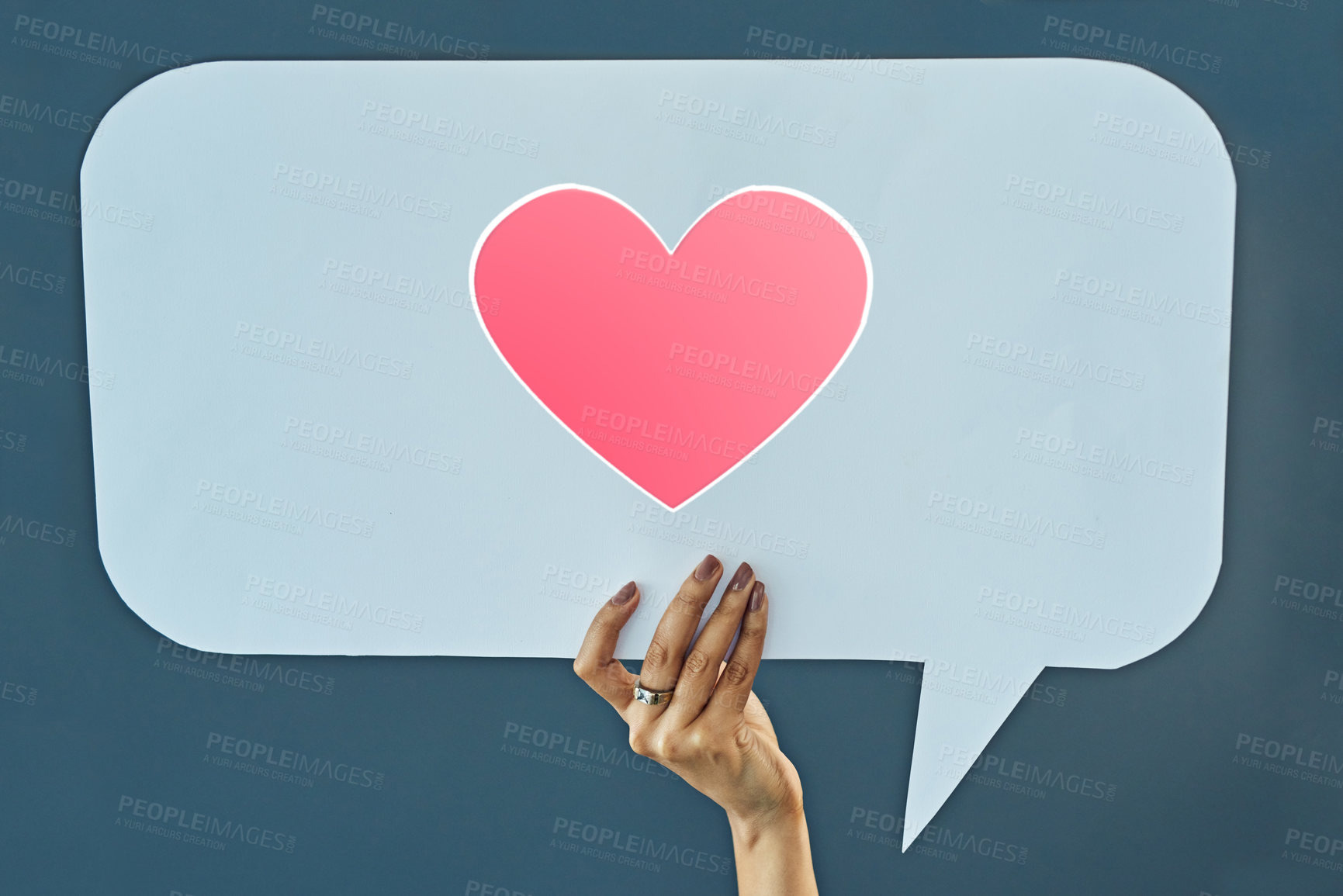 Buy stock photo Cropped studio shot of a woman holding up a speech bubble with a heart on it against a gray background