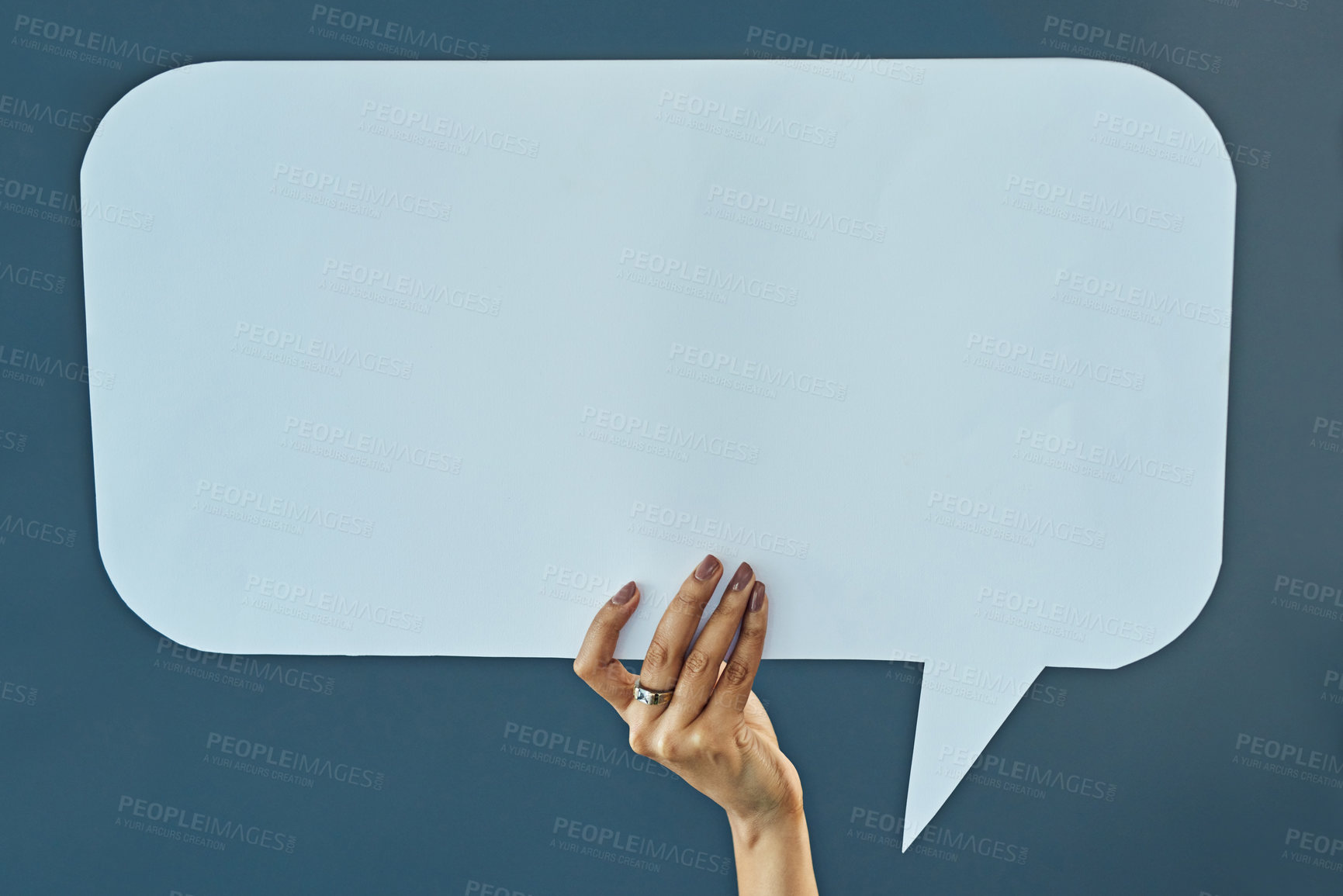 Buy stock photo Cropped studio shot of a woman holding up a blank speech bubble against a gray background
