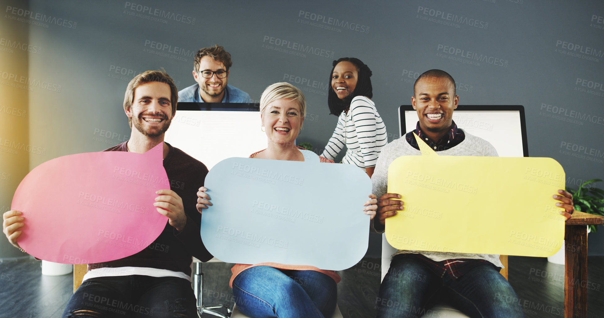 Buy stock photo Shot of a diverse group of people holding up speech bubbles in a modern office