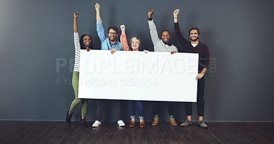 Buy stock photo Studio shot of a diverse group of people holding a blank placard and cheering against a gray background