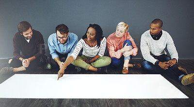 Buy stock photo Studio shot of a group of people sitting on the floor and working on blank paper against a gray background