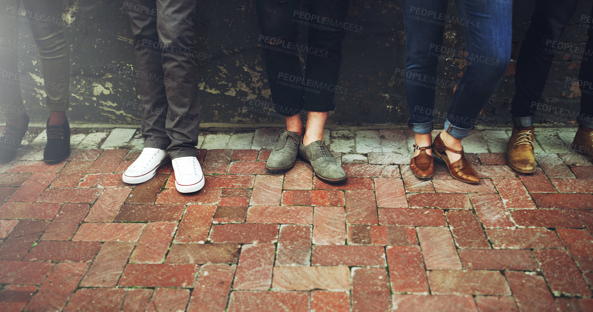 Buy stock photo Cropped shot of a diverse group of people standing together on a paved sidewalk