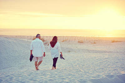 Buy stock photo Shot of a mature couple going for a relaxing walk on the beach