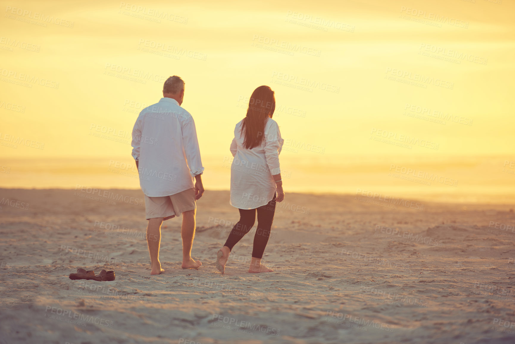 Buy stock photo Shot of a mature couple going for a relaxing walk on the beach