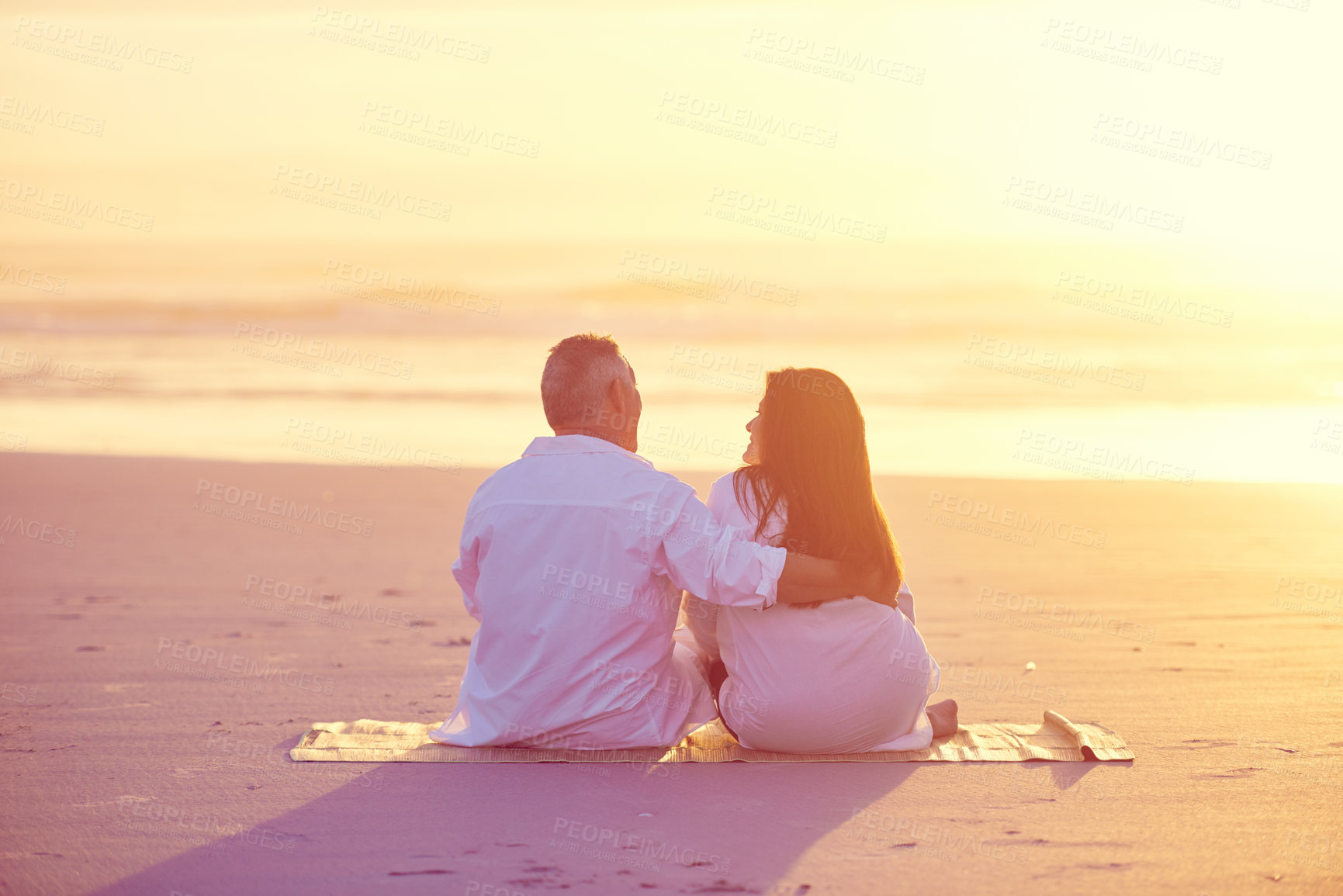 Buy stock photo Shot of a mature couple relaxing together on the beach