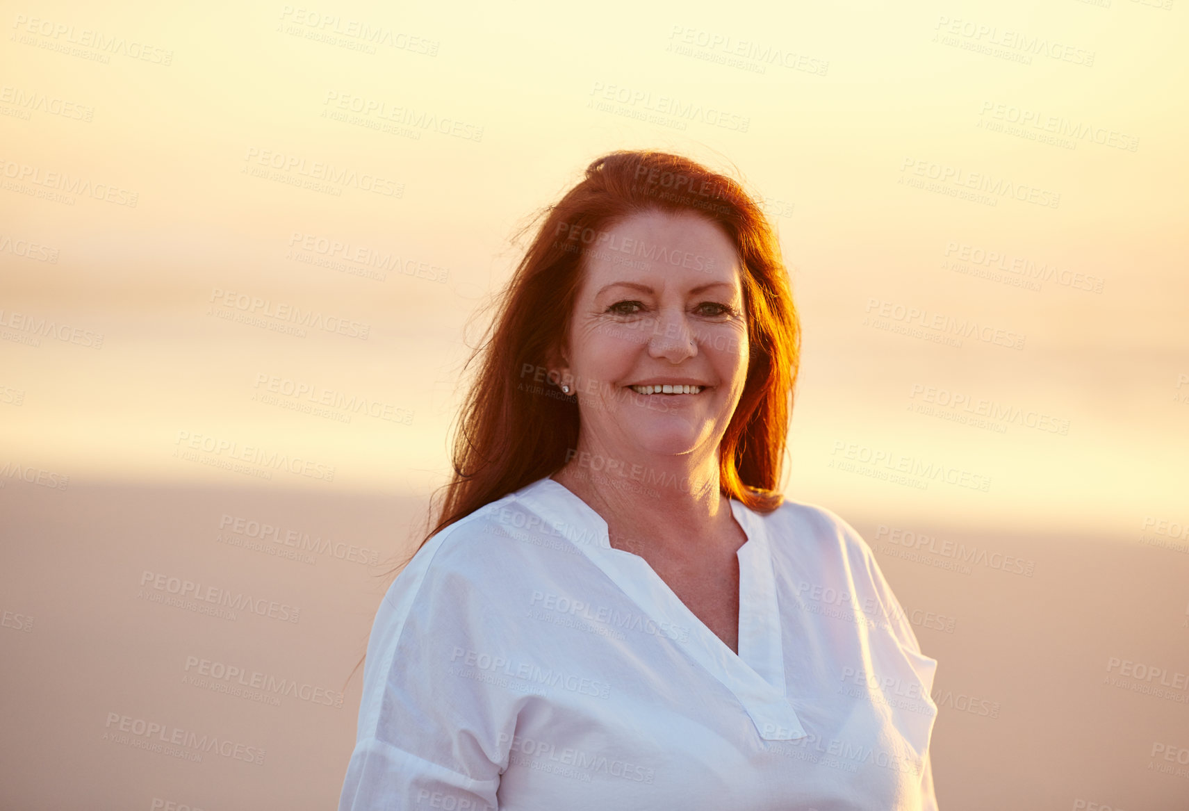 Buy stock photo Shot of mature woman standing on the beach at sunset
