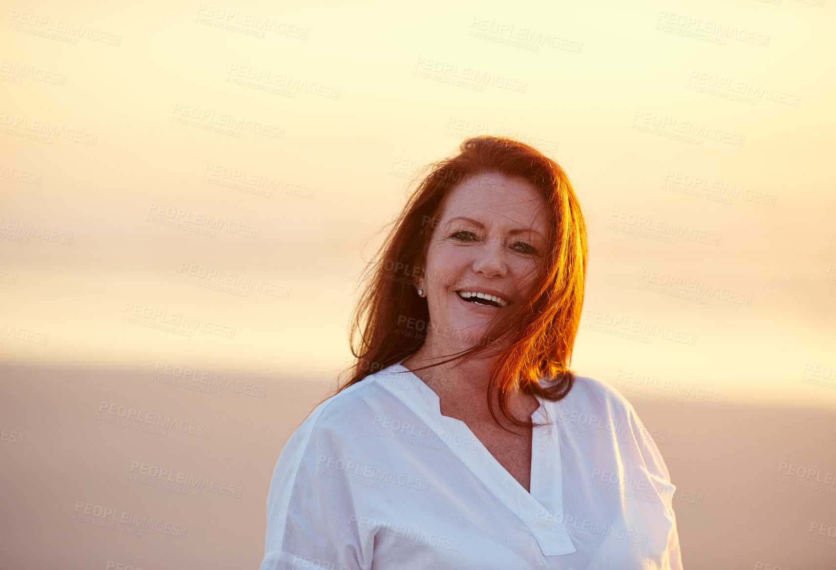 Buy stock photo Shot of mature woman standing on the beach at sunset