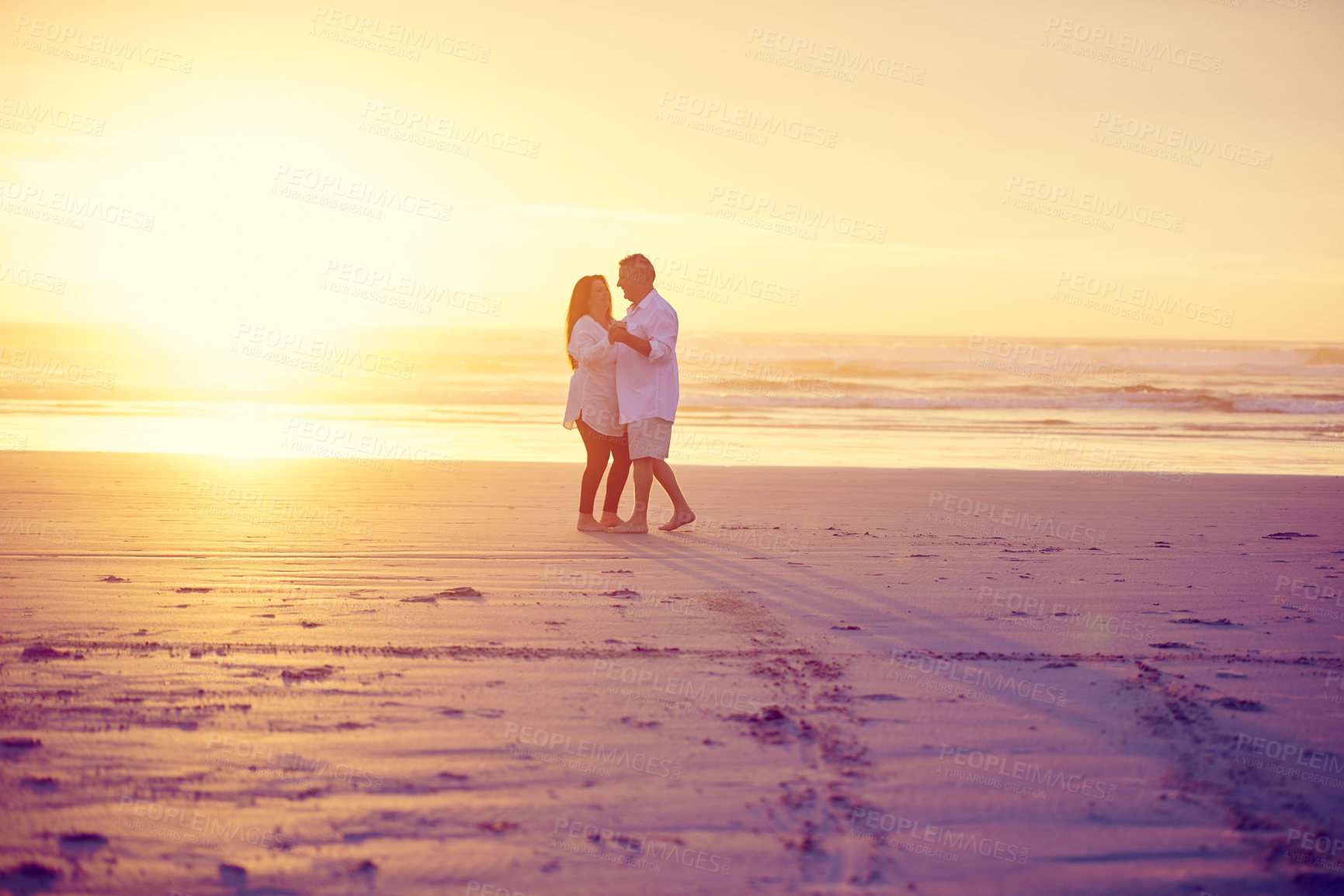 Buy stock photo Full length shot of an affectionate mature couple dancing on the beach at sunset