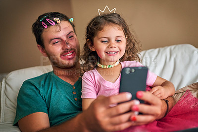 Buy stock photo Dad, daughter and playing on phone in home, dress up and subscription to online games on couch. Father, girl and surfing social media and website for cartoon videos, relax together and bonding on app