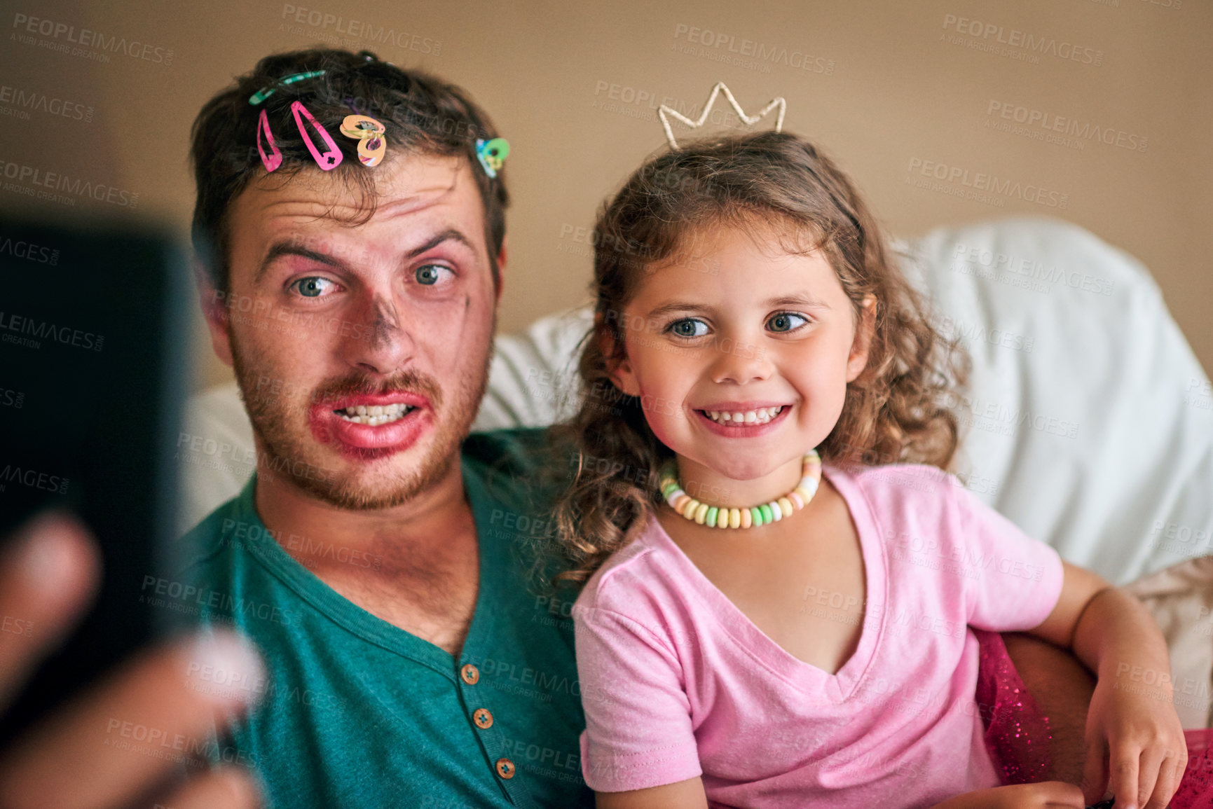 Buy stock photo Shot of a father and his little daughter taking a selfie together while playing dress-up at home