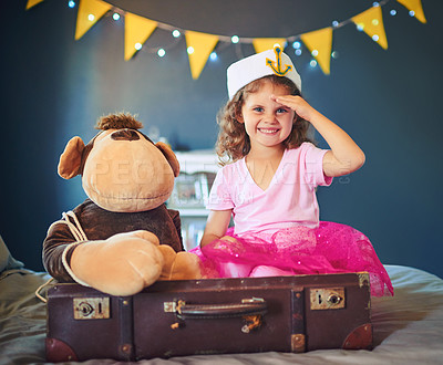 Buy stock photo Portrait of an adorable little girl dressed up as a sailor and playing on the bed at home