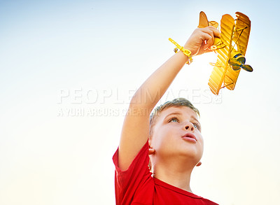 Buy stock photo Shot of a little boy playing with a toy plane outdoors