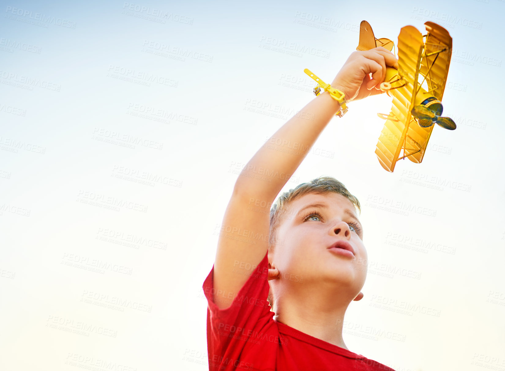 Buy stock photo Shot of a little boy playing with a toy plane outdoors