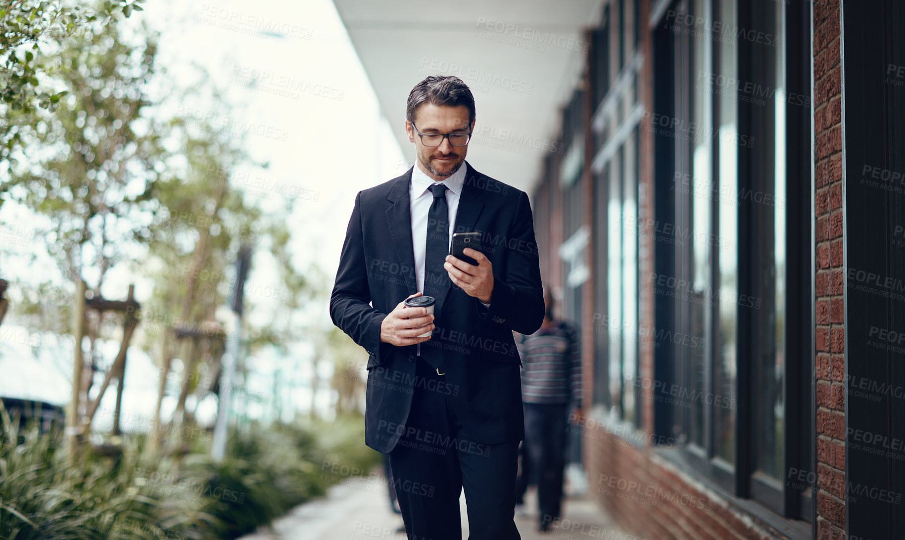 Buy stock photo Shot of a mature businessman texting on a cellphone while out in the city