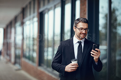 Buy stock photo Shot of a mature businessman texting on a cellphone while out in the city
