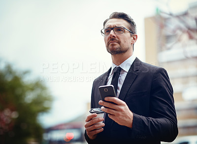 Buy stock photo Shot of a mature businessman texting on a cellphone while out in the city