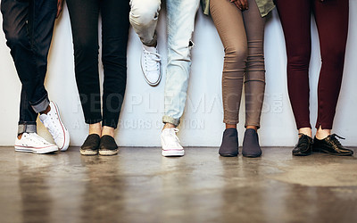 Buy stock photo Cropped shot of unrecognizable university students in a campus corridor