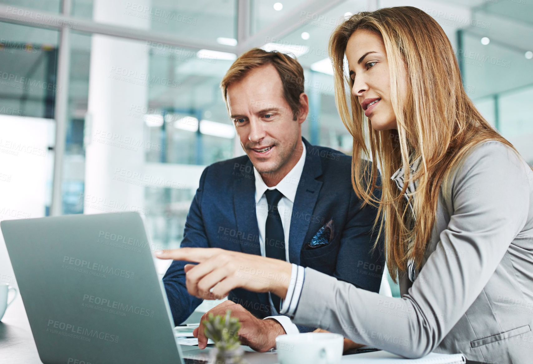 Buy stock photo Cropped shot of two businesspeople working together on a laptop